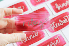 Load image into Gallery viewer, Acrylic place cards with hand-lettered names and rose-coloured painted backs. 
